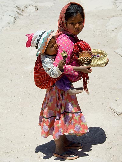 Tarahumara girl Nola carrying her brother Reyo.